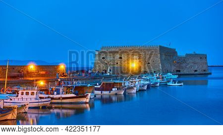 Heraklion in Crete Island, Greece.  Harbor with fishing boats by the old venetian fortress at dusk