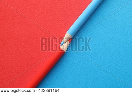Red-blue Pencils Pointed Towards Each Other On Red-blue Background