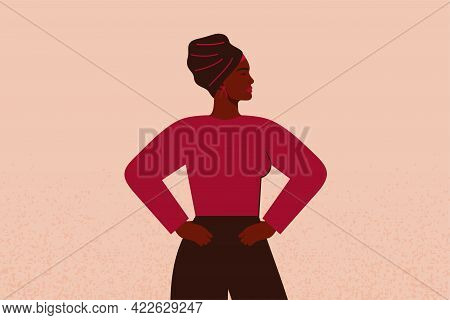 Strong Black Girl In Head Scarf With Hands On Her Hips Looks Forward. Confident Businesswoman Or Ent