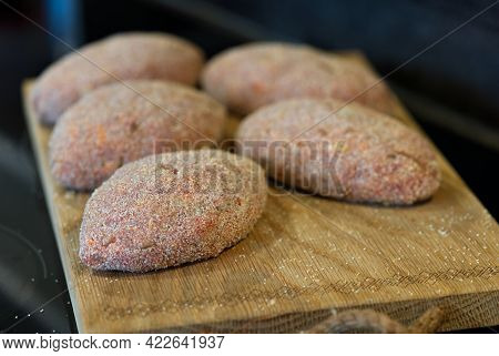 Raw Cutlets Made Of Ground Beef Meat On A Rustic Chopping Board. Homemade Cutlets