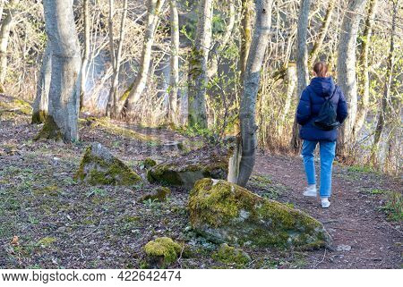 Young Woman With Backpack Walking In The Forest On Sunny Day