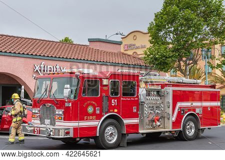 Lompoc, Ca, Usa - May 26, 2021: Closeup Of Red Fire Engine In Town With Officer And In Front Of Hilt