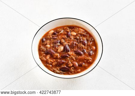 Stewed Beans With Ground Beef, Jalapeno Pepper And Bacon In Bowl On Light Stone Background. Close Up