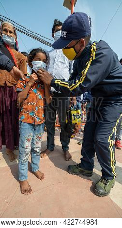 Haridwar, Uttarakhand India April 06, 2021. Policemen Wearing Protection Mask To A Child To Stay Saf