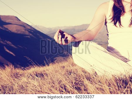 Woman Meditating in Lotus Position on Top of a Mountain
