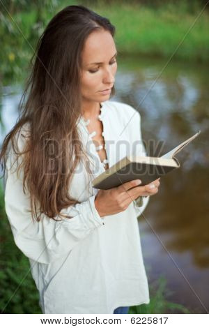 Lecture jeune femme près de la rivière