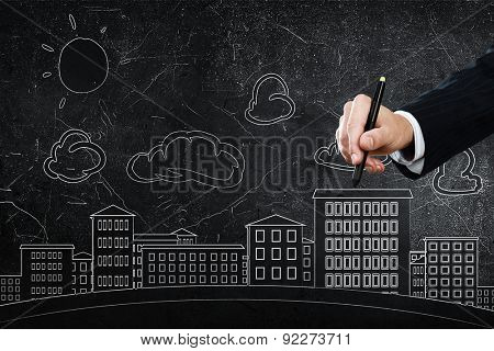 Close up of hand drawing urban city buildings