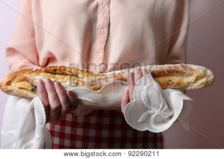 Woman holding tasty fresh bread, close up