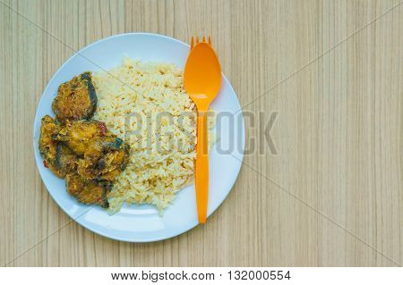 Thai food is name chu chi pla with steamed rice on wood background