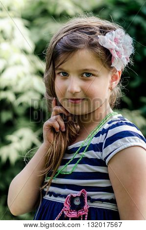 Cute little girl with a flower in her hair, summer portrait.
