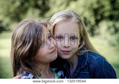 Portrait of two long haired preteen girls while smiling.