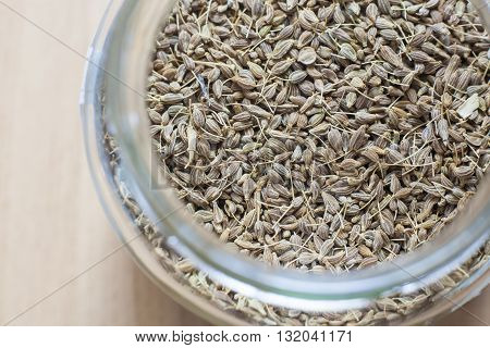 Glass jar with anise over wooden surface. Selective focus. High angle view
