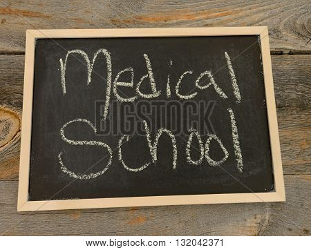 Medical school written in chalk on a chalkboard on a rustic background