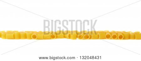 Line made of dry ditalini yellow pasta over isolated white background