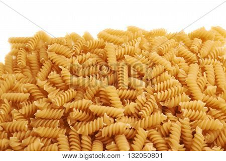 Pile of dry rotini yellow pasta over isolated white background