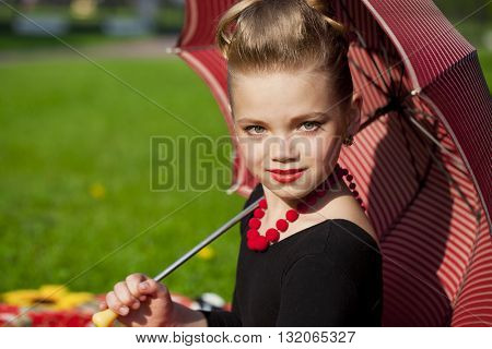 Pin-Up. Lovely little girl in the retro red dress in summer park