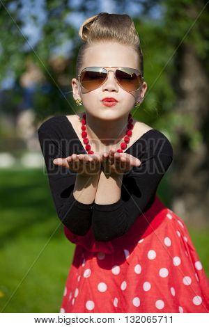 Pin-Up. Lovely little girl in the retro red dress in summer park