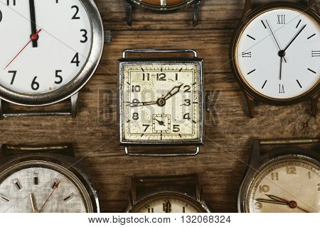 A selection of retro and antique watches over old wood background. Filtered to look like an aged instant photo.