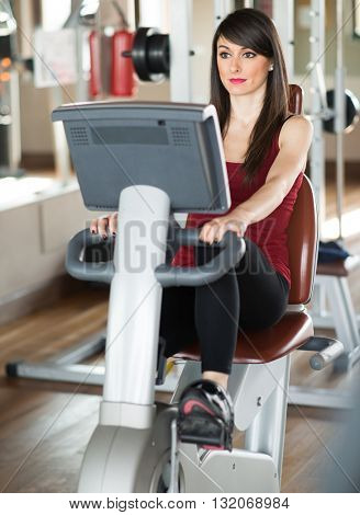 Woman working out on a stationary bike in a gym