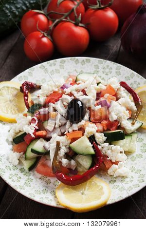 Shopska salad with cheese, olives, tomato, cucumber, onion and chili peppers