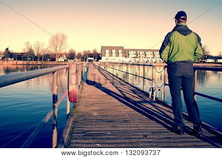 Tourist Wlk On Wharf Construction Above  Sea To Harbor. Clear Blue Sky, Calm Water Level