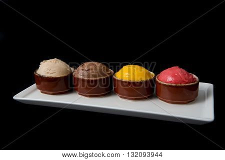Four different ice cream sorts on a black background