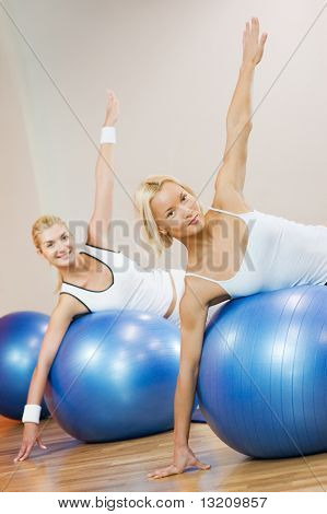 Skupina lidí, kteří dělají fitness cvičení s míčem