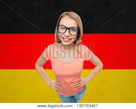 vision, education, national and people concept - happy smiling young woman or teenage girl eyeglasses over german flag background