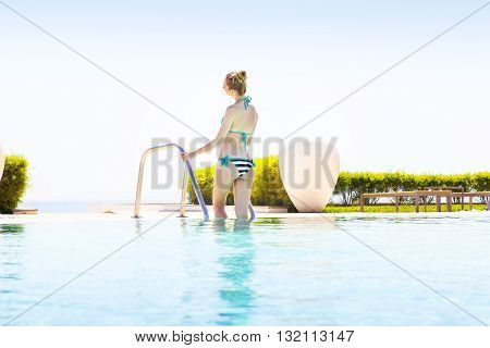 Pretty blond woman enjoying a swimming pool