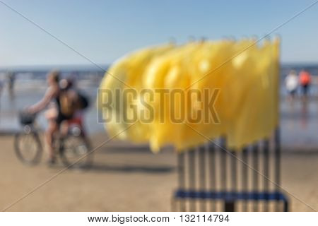 A lot of yellow flags in the wind and cyclist in the Baltic Sea beach. Blurry