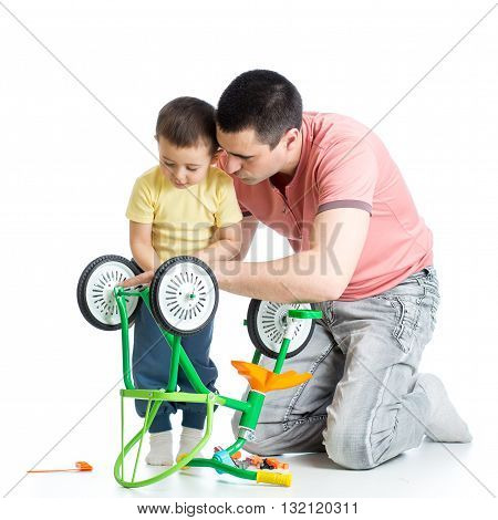 Child boy and his daddy fixing bisycle