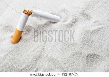 Quit Smoking - Broken Unsmoked Cigarette In Sand With Copyspace