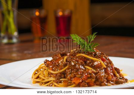 Traditional italian Bolognese with spaguetti over a wooden table