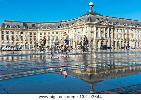People Riding Bicycles In The Fountain In Bordeaux, France