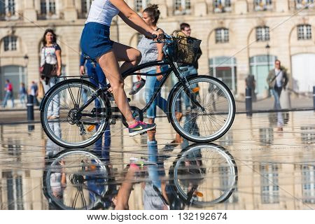 People Riding Bicycles In The Fountain In Bordeaux, France