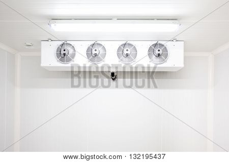 an empty industrial room refrigerator with four fans