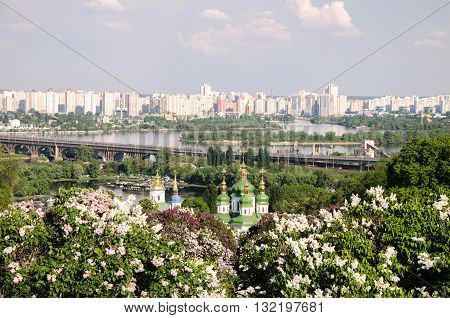 orthodox church on the background of the river and the big city in a lavender garden