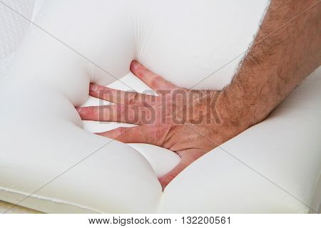 a male hand touching and testing mattress