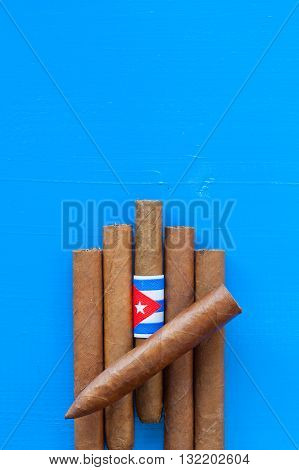 Detail of luxury Cuban cigars on the blue desk