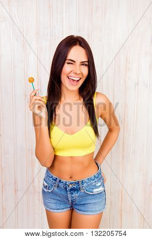 Attractive Cheerful Woman Holding Chupa Chups And Winking