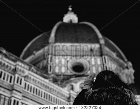 woman photographing the dome of Florence Cathedral at night