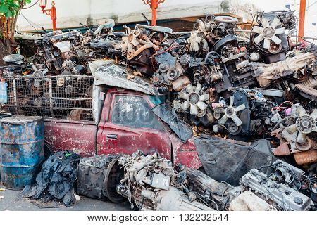 Pickup truck buried under a lot of car engines on the street of Bangkok
