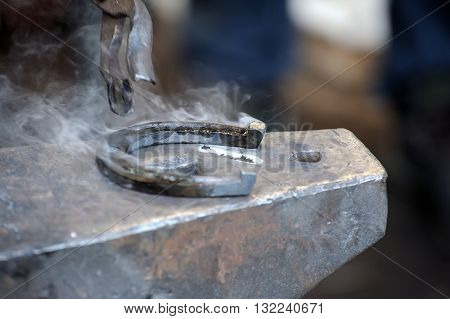Blacksmith forges a horseshoe for horse close-up