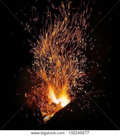 smithy fire flame tips with sparks closeup on dark background