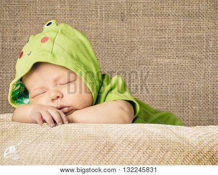 New Born Baby Sleeping wth green dress on white blanket