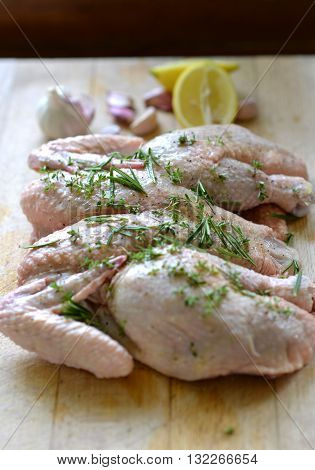 Raw spatchcock chicken with garlic herbs and lemon