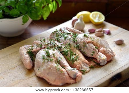 Raw spatchcock chicken with garlic herbs and lemon