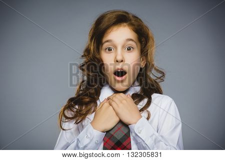 Portrait of happy girl going surprise on gray background.