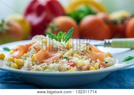 Fresh quinoa and cuscus salad with smoked salmon on plate