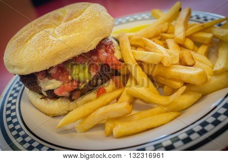 Cheeseburger on a kaiser roll with steak fries on the side
